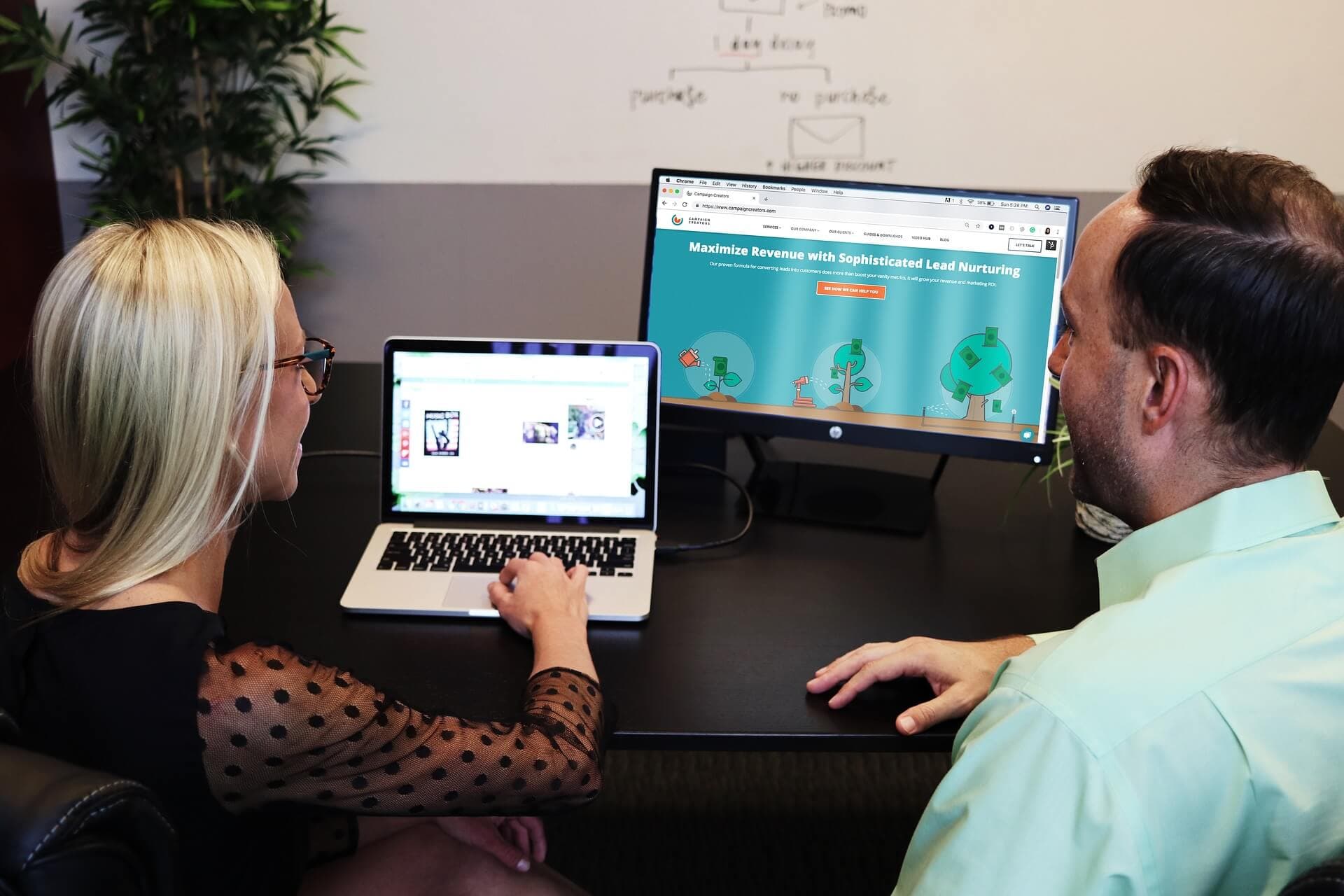 Man and woman using a laptop in an office together